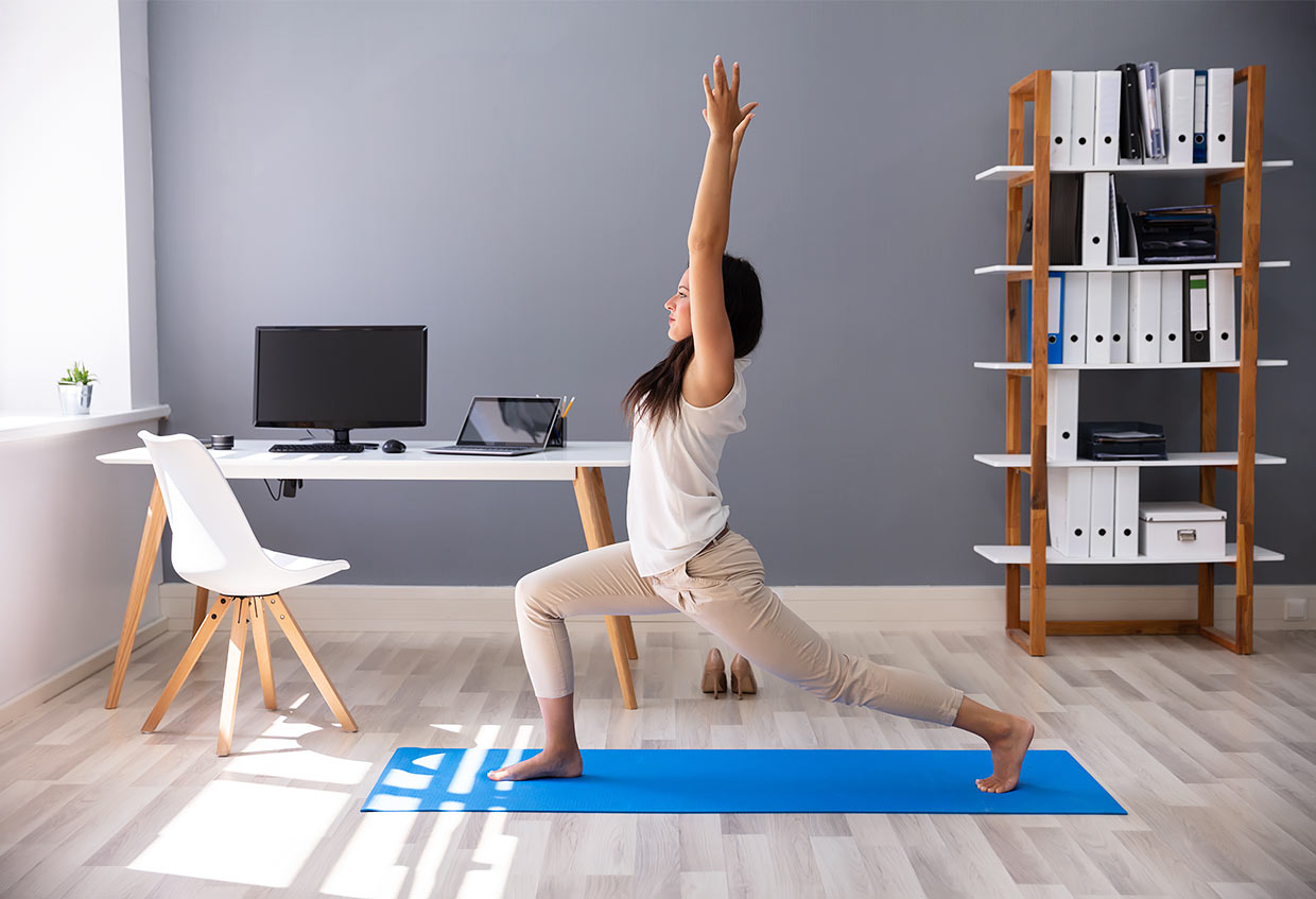 Woman performing yoga in her office
